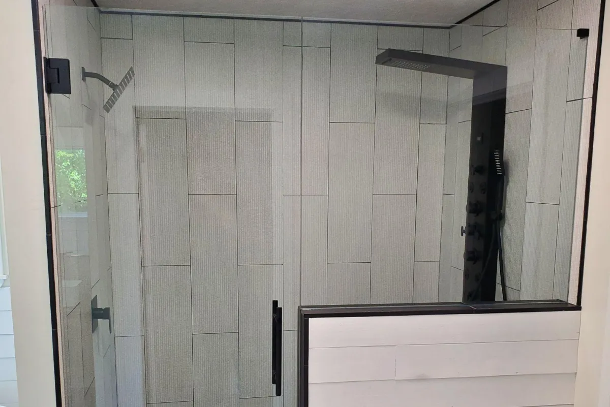Custom frameless glass shower with gray tile wall and black shower handle in Centerville OH