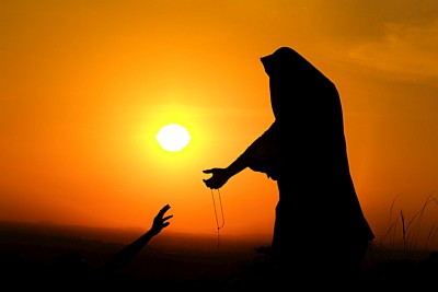 Woman in light reaching her hand out