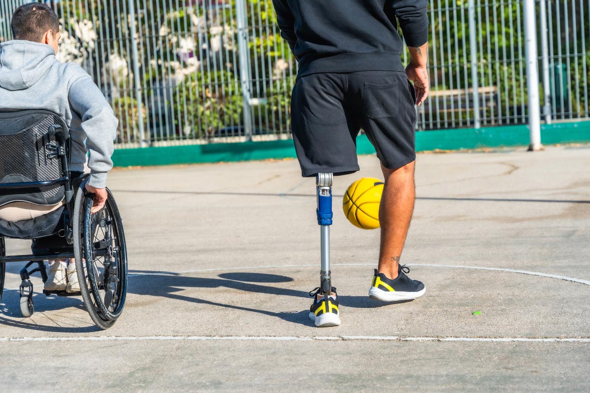 Person with a below-knee prosthetic leg kicking a basketball, demonstrating safe and active movement for diabetic amputees.
