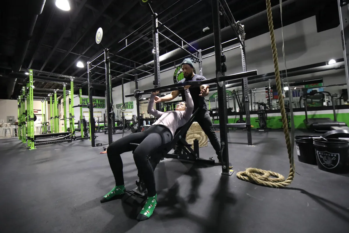 Woman bench pressing a multigrip bar