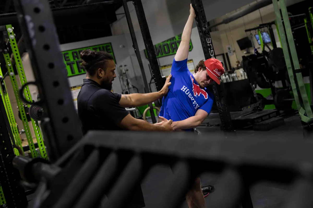 Trainer showing client a stretch movement