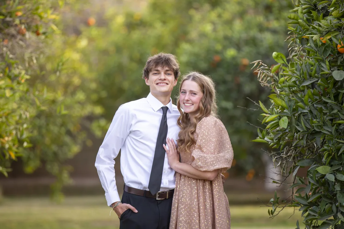 Pre-Dance Portraits: Couple posing in front of an orange grove before the dance.