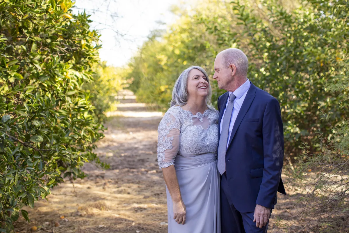 Bride and groom portraits in front of a line of trees