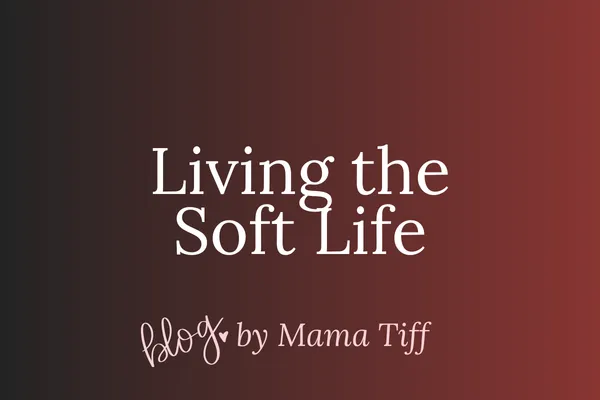 Woman lounging in bed under blankets, sipping tea, creating and resting in a cozy sanctuary.