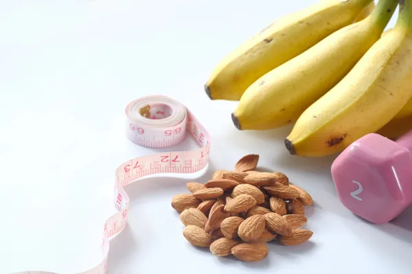 banana, tape measure, nuts, dumbbell representing weight loss efforts