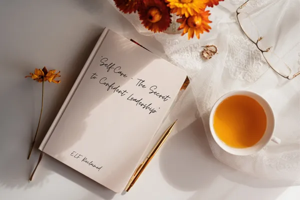 Notebook on a table with a cup of tea and some flowers
