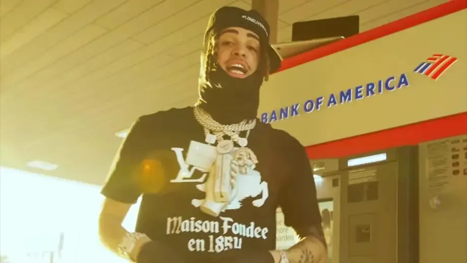 rapper with cash in front of ATM