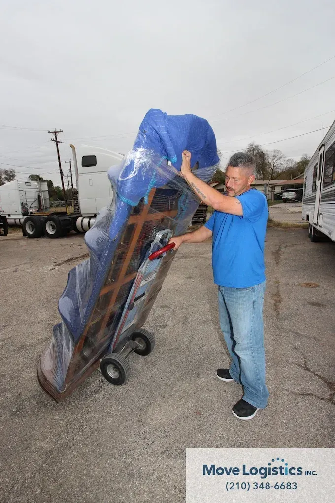 Move Logistics crew member safely transporting packed items for moving