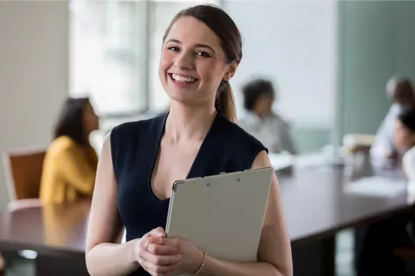 glückliche VA mit notepad in den Händen und dunkel blauem Top