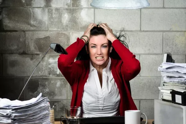Frau am Schreibtisch rauft sich die Haare