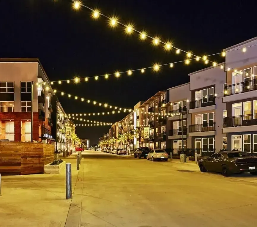 A cozy street scene at night, featuring twinkling lights strung across, enhancing the ambiance of the quiet surroundings.