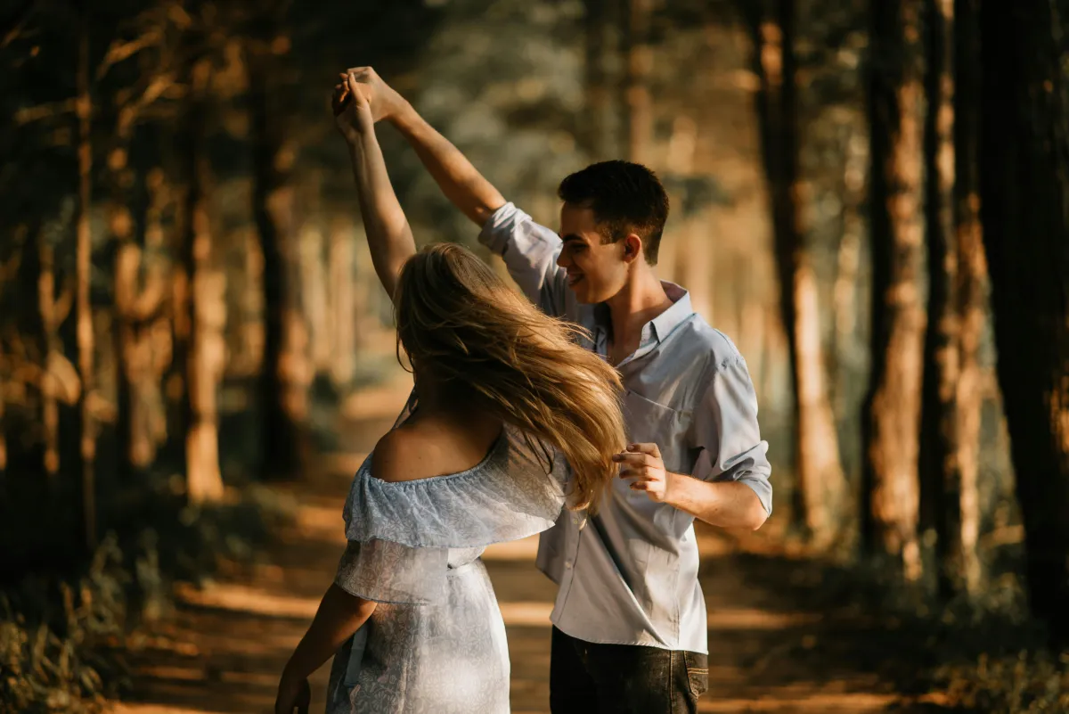 Couple twirling together in the woods