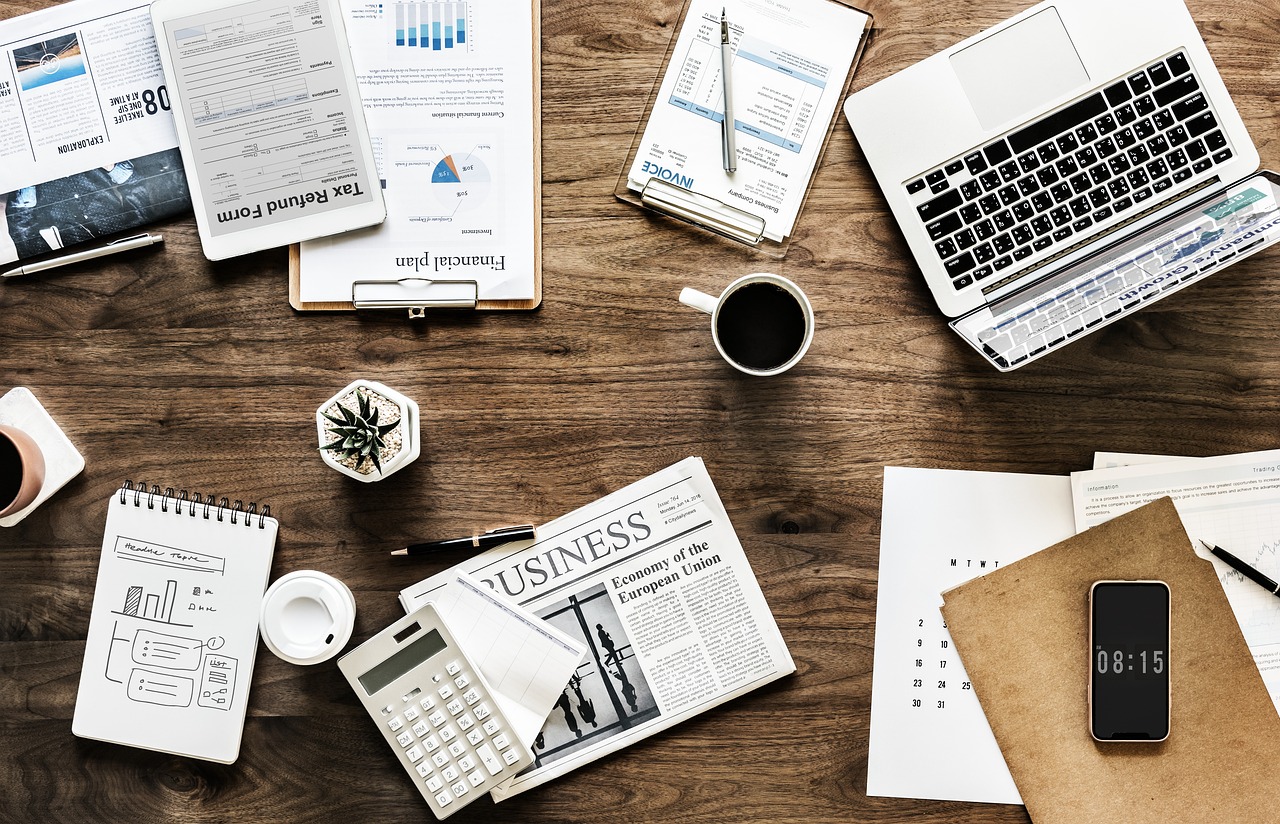 Overhead workspace with financial documents, calculator, laptop, and coffee—mortgage planning and budgeting concept.