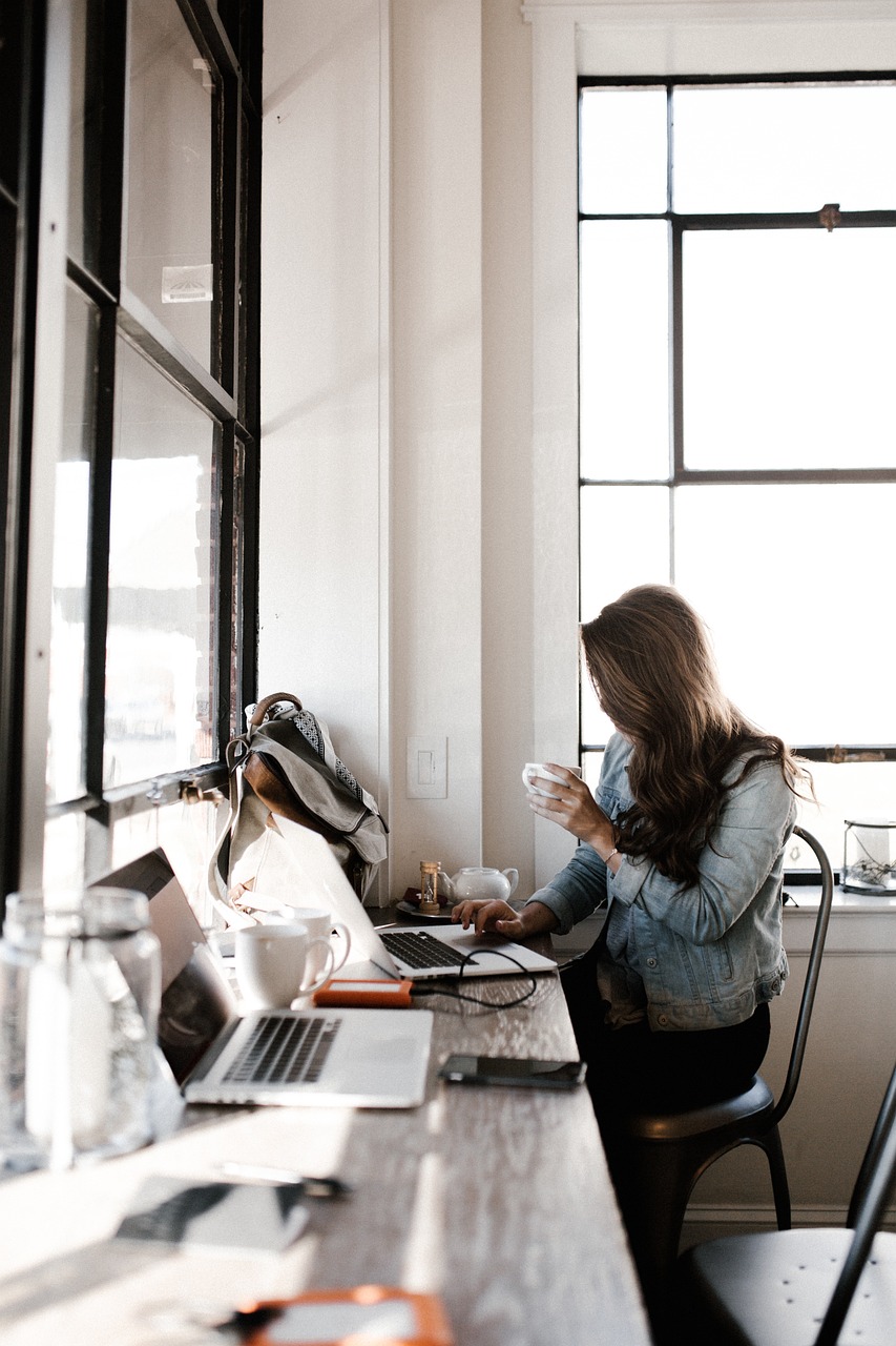 Women sat working at desk, in an office space.