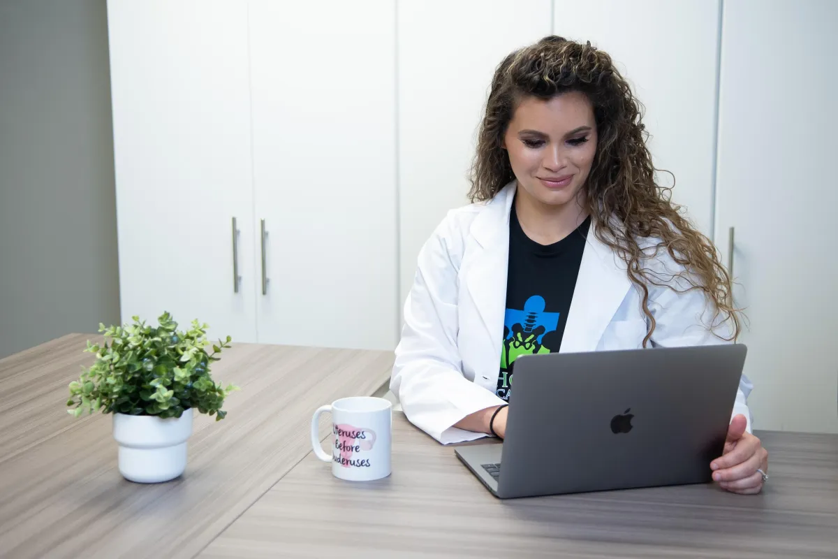 Dr. Kelly Alhooie works on her laptop at her clinic.
