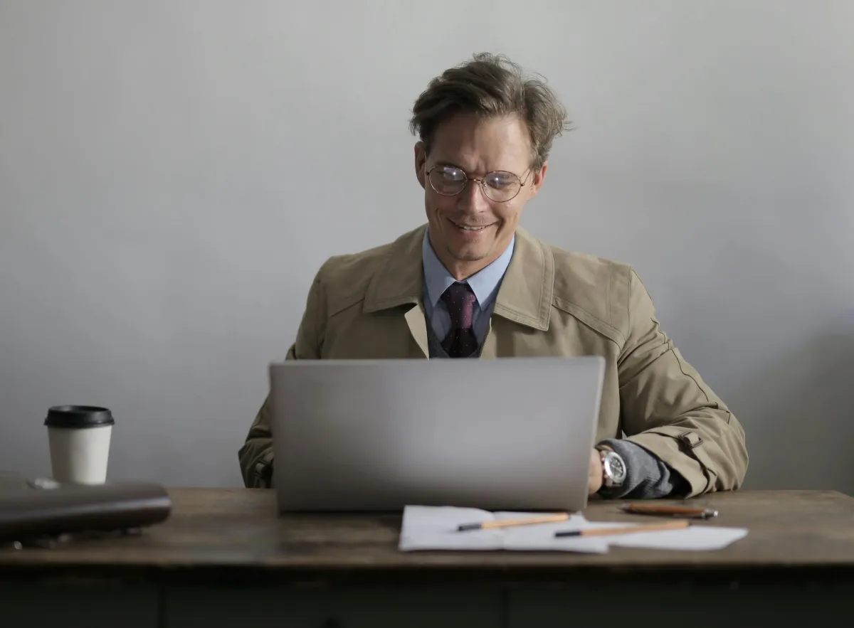 Smiling businessman using laptop netbook on a table
