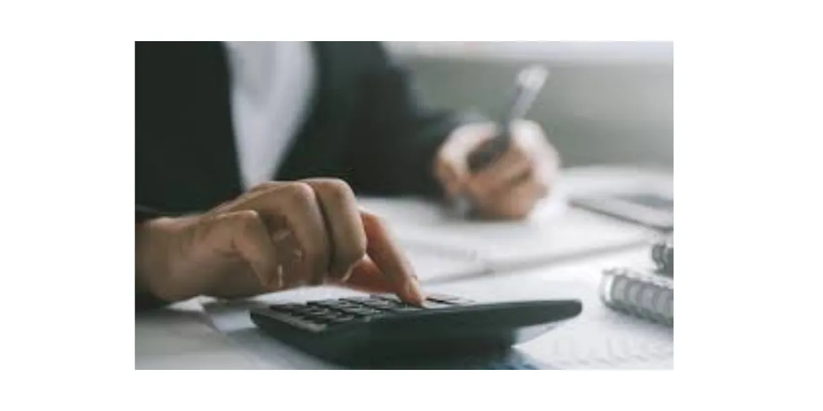 Person using a calculator with legal documents in the background, representing will pricing.