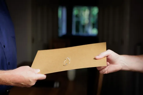 A Will in a folder being handed over to another person