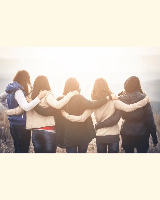 Women standing together with arms linked, representing CR Multitalented’s faith-led trauma-informed community.