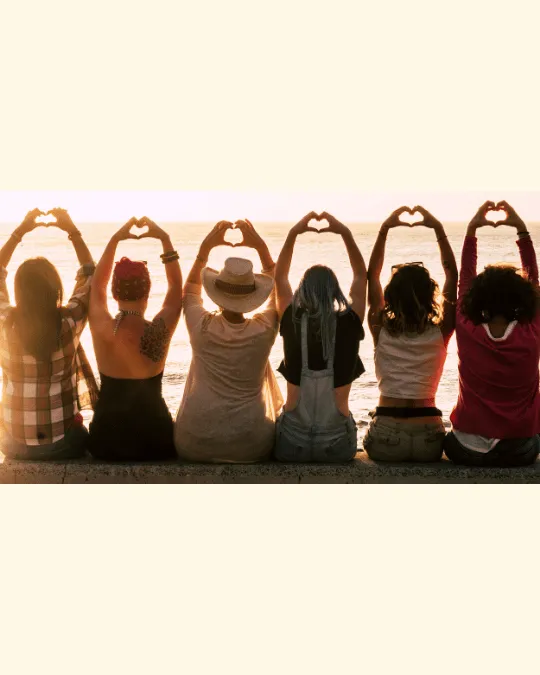 Silhouettes forming heart shapes at sunset, showing the unity and hope behind the Break Free & Rise mission.