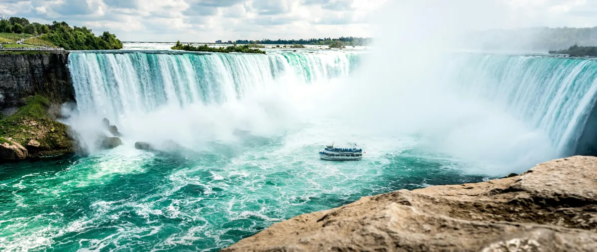 Niagara Falls Horseshoe Falls with tour boat cruising through mist on a day trip from Toronto