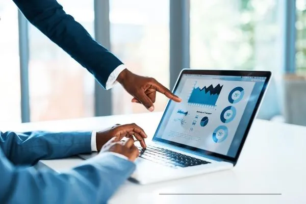 Picture of a small business owner pointing at a CRM system showing an employee