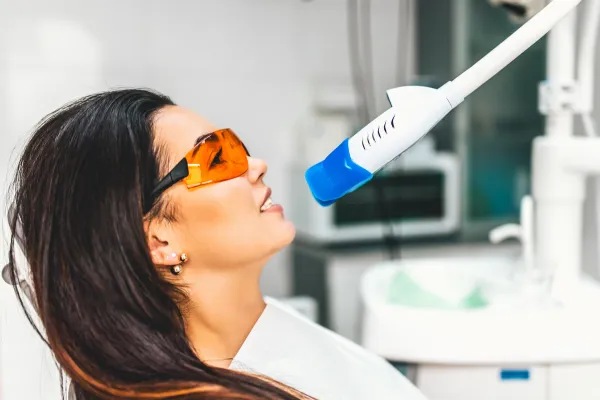 Woman sitting in dentist office getting her teeth whitened