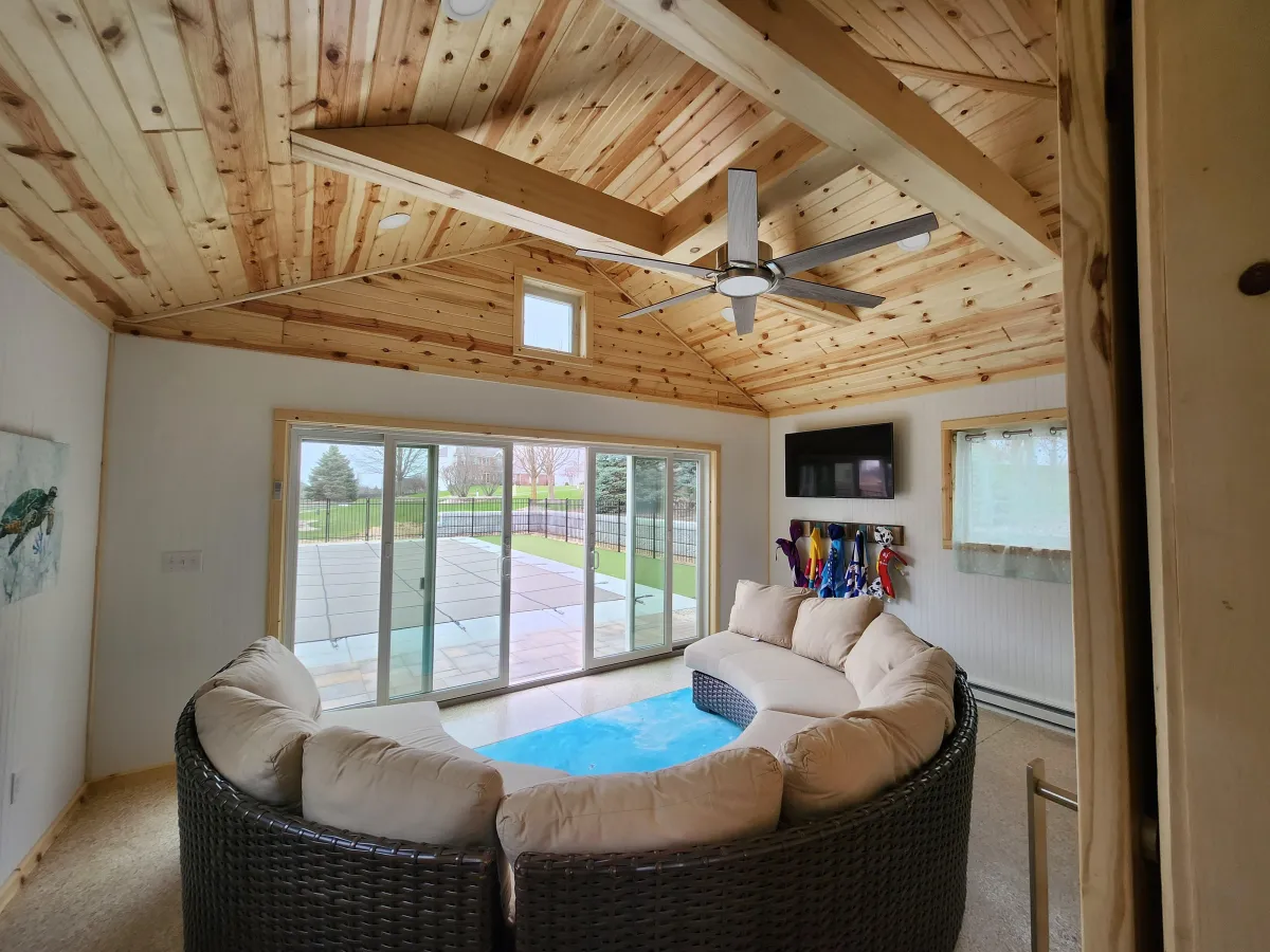 Custom pool house built by M.G.K. Contracting in Northern Illinois – vaulted ceiling with exposed beams, car-siding walls, custom carpentry and double patio doors opening to pool