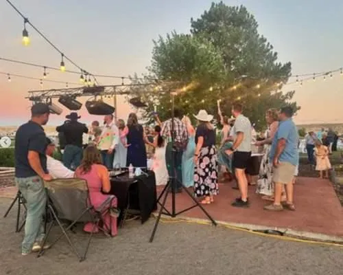 Wedding guests celebrating in front of a DJ. Keg and Barrel served the wedding with their mobile bar in Twin Hills, ID.