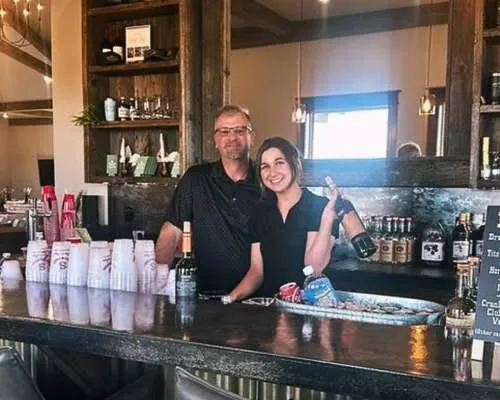 Two bartenders for Keg and Barrel smile for the camera behind the bar. They are preparing for an event that day in Twin Falls.