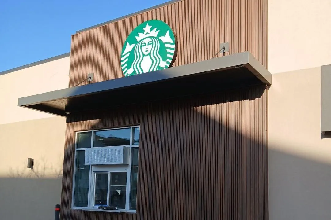 Modern commercial canopy installed above a Starbucks drive-thru window, providing shade and weather protection.