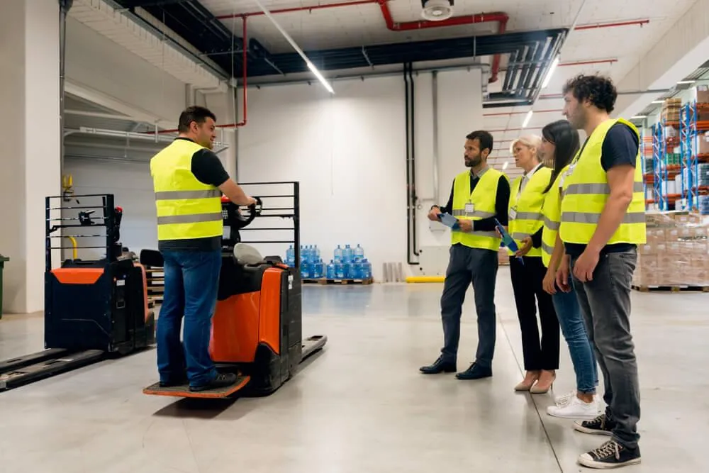 5 individuals wearing yellow vest in a forklift operating training