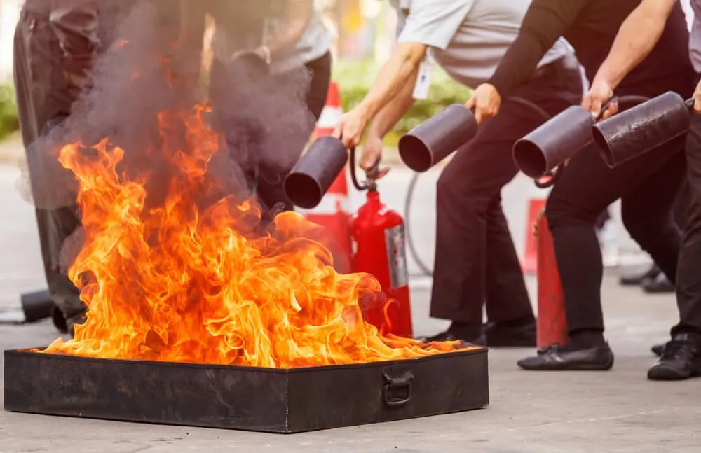 A flaming fire being fired out with fire extinguishers for training