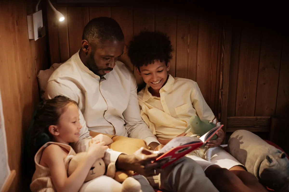 A father reading with their two children