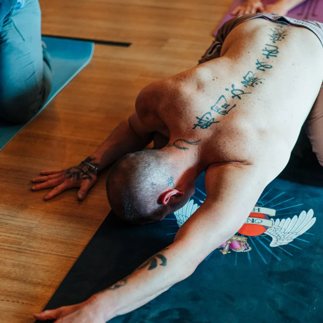 A calm yoga practitioner sitting cross-legged in meditation at sunrise, overlooking a scenic mountain landscape—symbolising inner peace and ancient wisdom amidst modern life challenges.