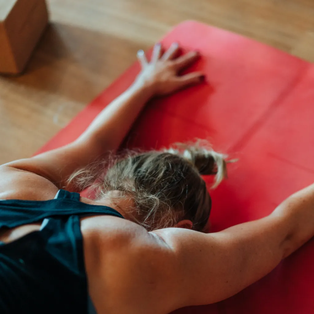 Person practising grounding breathwork with hands on the body, calming the nervous system and soothing emotional overwhelm.