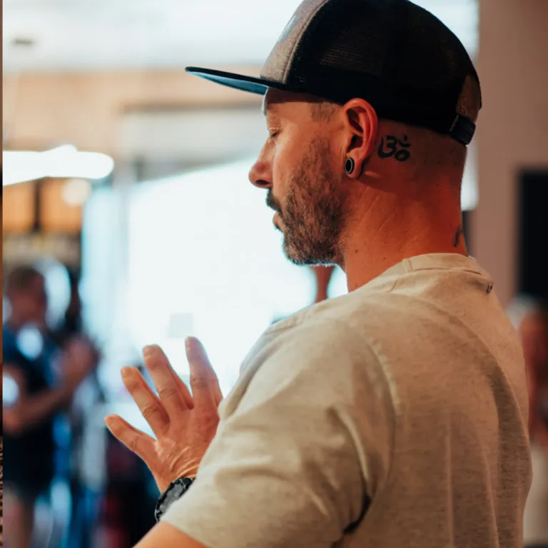 Person journalling in a notebook with a warm drink nearby, practising a gratitude list to shift mindset and improve emotional wellbeing.