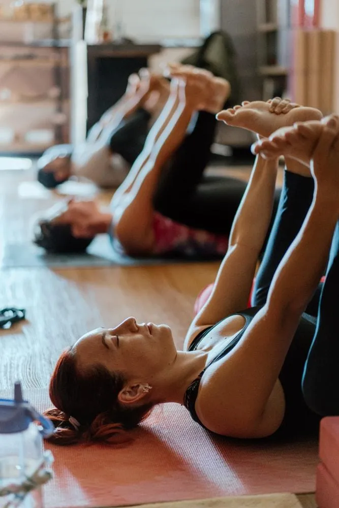 Person practising a hip-opening yoga pose in a peaceful studio space, breathing steadily to release tight hips and improve mobility.
