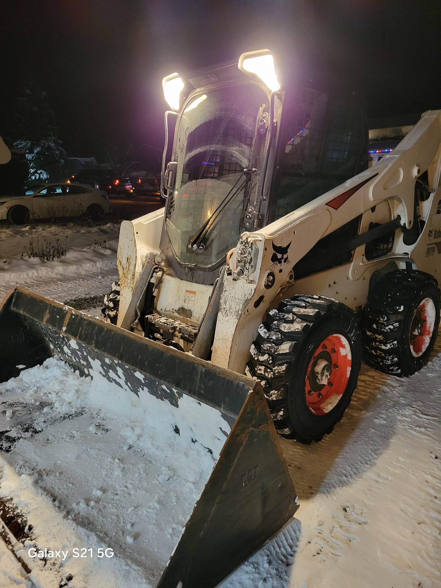 Bobcat S770 bucket attachment with operational headlights showing front-end capability