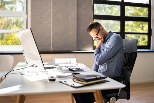 man sitted at a desk with bad posture blog post cover