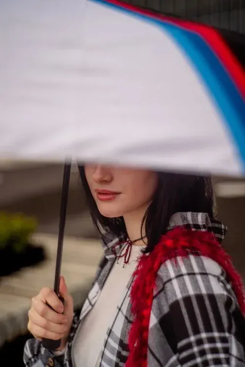 women holding an umbrella to protect her hair in rainy weather in sherman texas