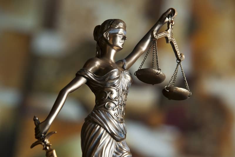 Statue of a bronze lady holding scales.