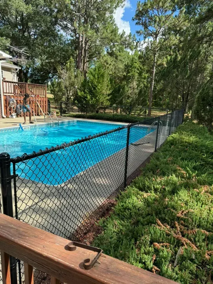 MCM Fence LLC installation of a black vinyl chain link pool safety fence for a residential property in Georgia.