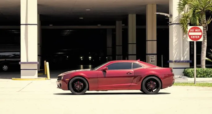 Red car parked in California city — visual representation of what it costs to register your car with DMV fees and taxes.