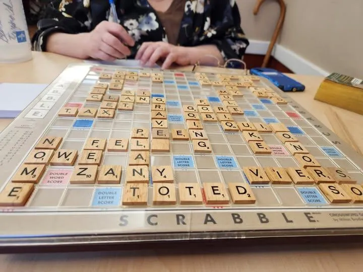 Senior woman playing Scrabble during a companionship visit in Blue Springs