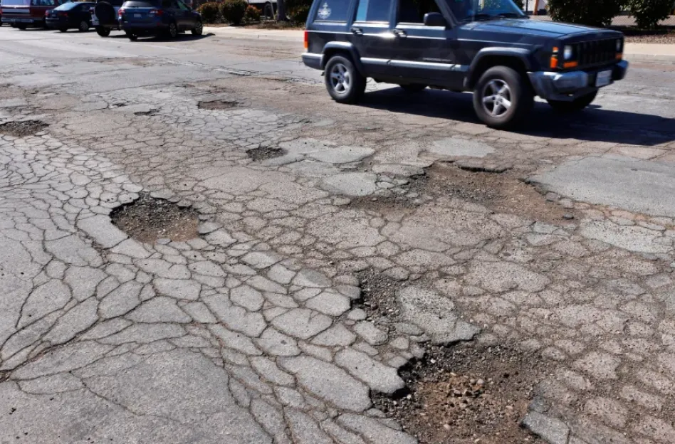 A driver drives on the wrong side of the road to avoid potholes on Vickers Street in Kearny Mesa on Wednesday, April 30, 2025. (K.C. Alfred / The San Diego Union-Tribune)