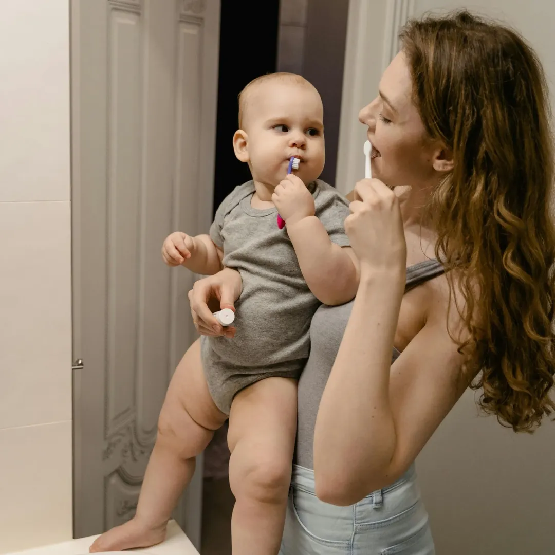 A mother brushing together with her child