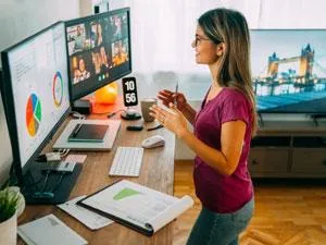 Woman Drinking Coffee Standing in Front of Computer