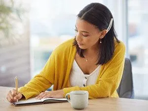 Woman yellow sweater journaling