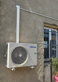 Unité extérieure de climatisation Panasonic installée sur un mur, avec goulotte blanche verticale et supports antivibratiles par AFO Énergies à Toulouse.